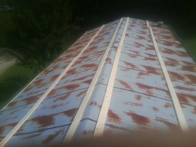 Rusted metal roof panels with new wood purlins before replacement — Storm Damage Roof Repair in Fort Drum by Roofing Brothers