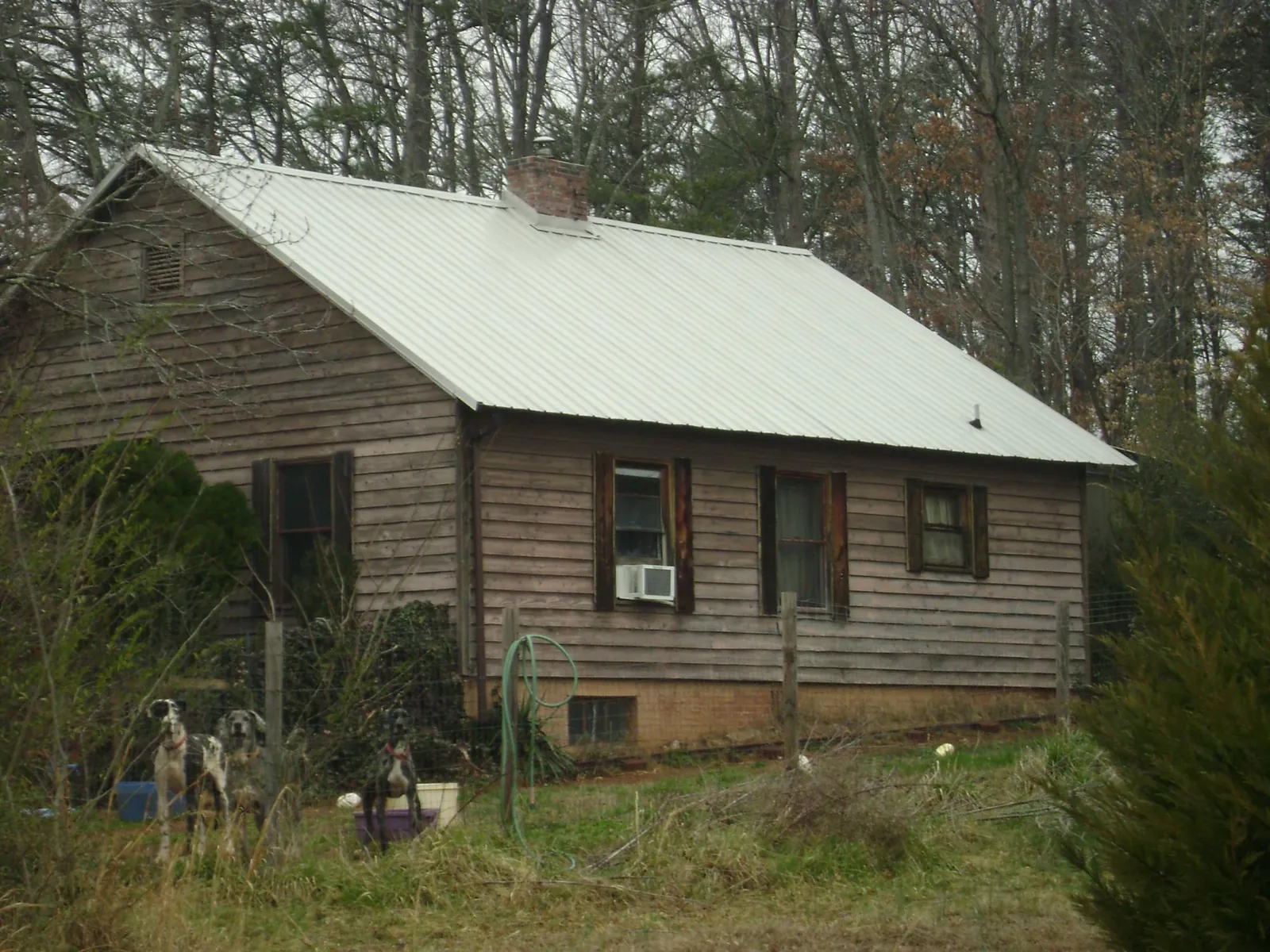 White metal roof on an old wood sided farmhouse, from a Metal Roof Installation job in Fort Drum